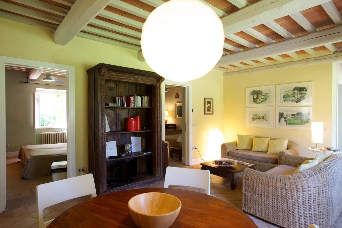 Un salon chaleureux avec une table à manger en bois, un canapé et une bibliothèque.