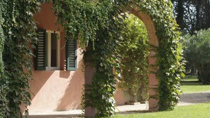 Un edificio con contraventanas verdes y paredes cubiertas de hiedra.