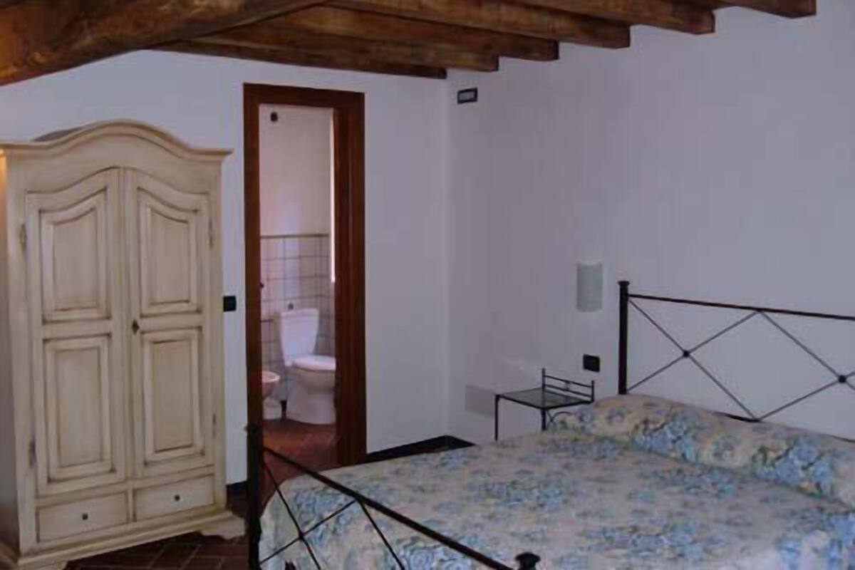 Une chambre à coucher comprenant un lit, une armoire et une porte donnant sur une salle de bain.