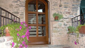 Un edificio de piedra con puerta de madera y un pequeño porche.