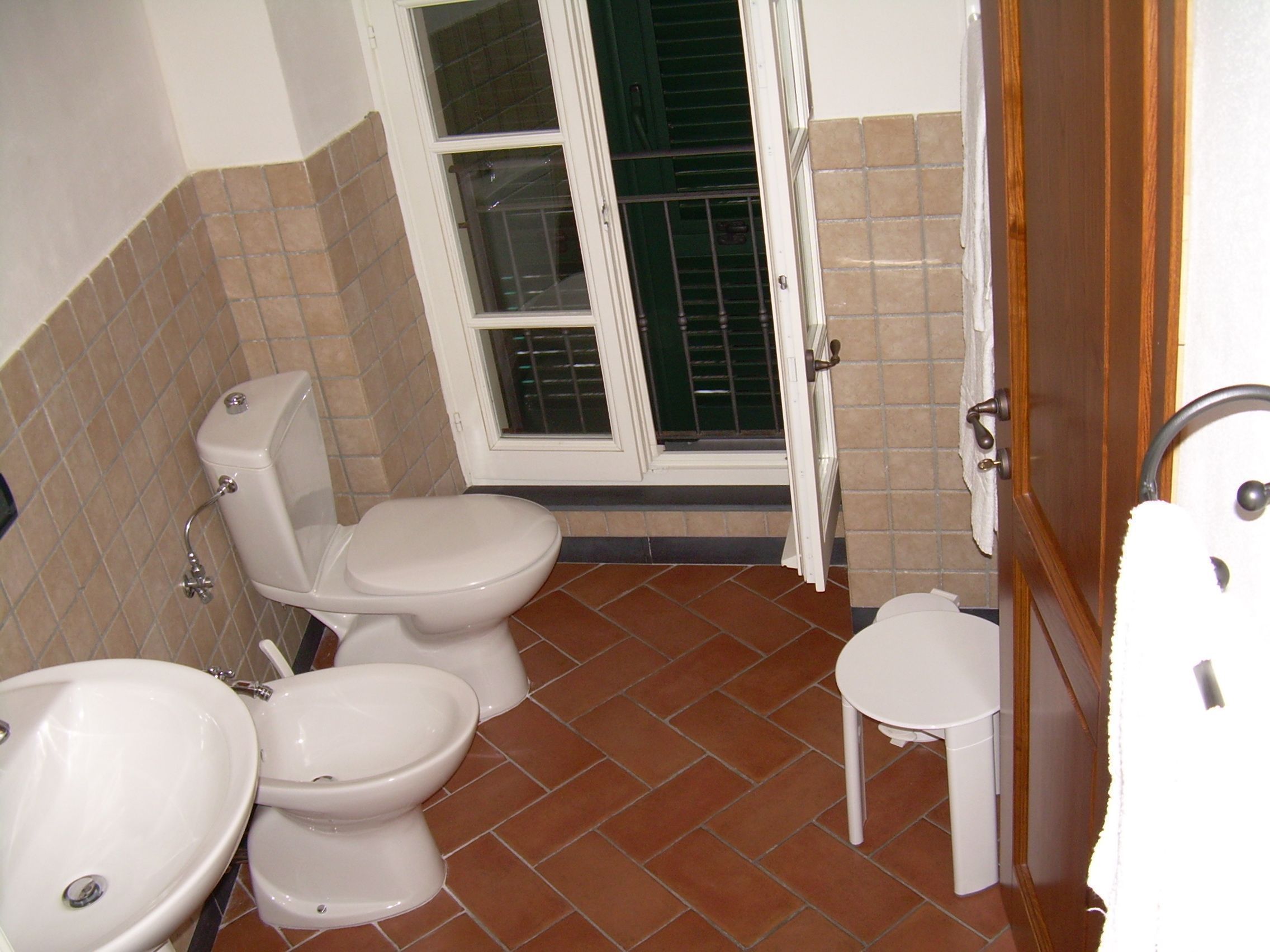 Une salle de bain équipée de toilettes, d’un bidet et d’un lavabo.