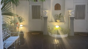 A covered patio area with a bench, potted plants, and a wall-mounted planter with plants. - Piazza di Spagna Prestige (Rome)