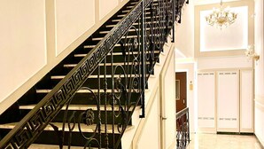 A grand staircase with ornate black metal railings and marble flooring. - Piazza di Spagna Prestige (Rome)