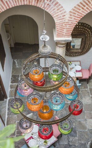 A chandelier with multiple colorful glass shades hanging from a metal frame.