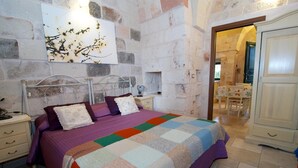 A bedroom with a bed, a nightstand, a dresser, and a painting on the wall. - Relais Villa Lucia (Carovigno)