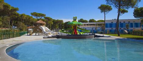 A swimming pool with a slide and a water play area.