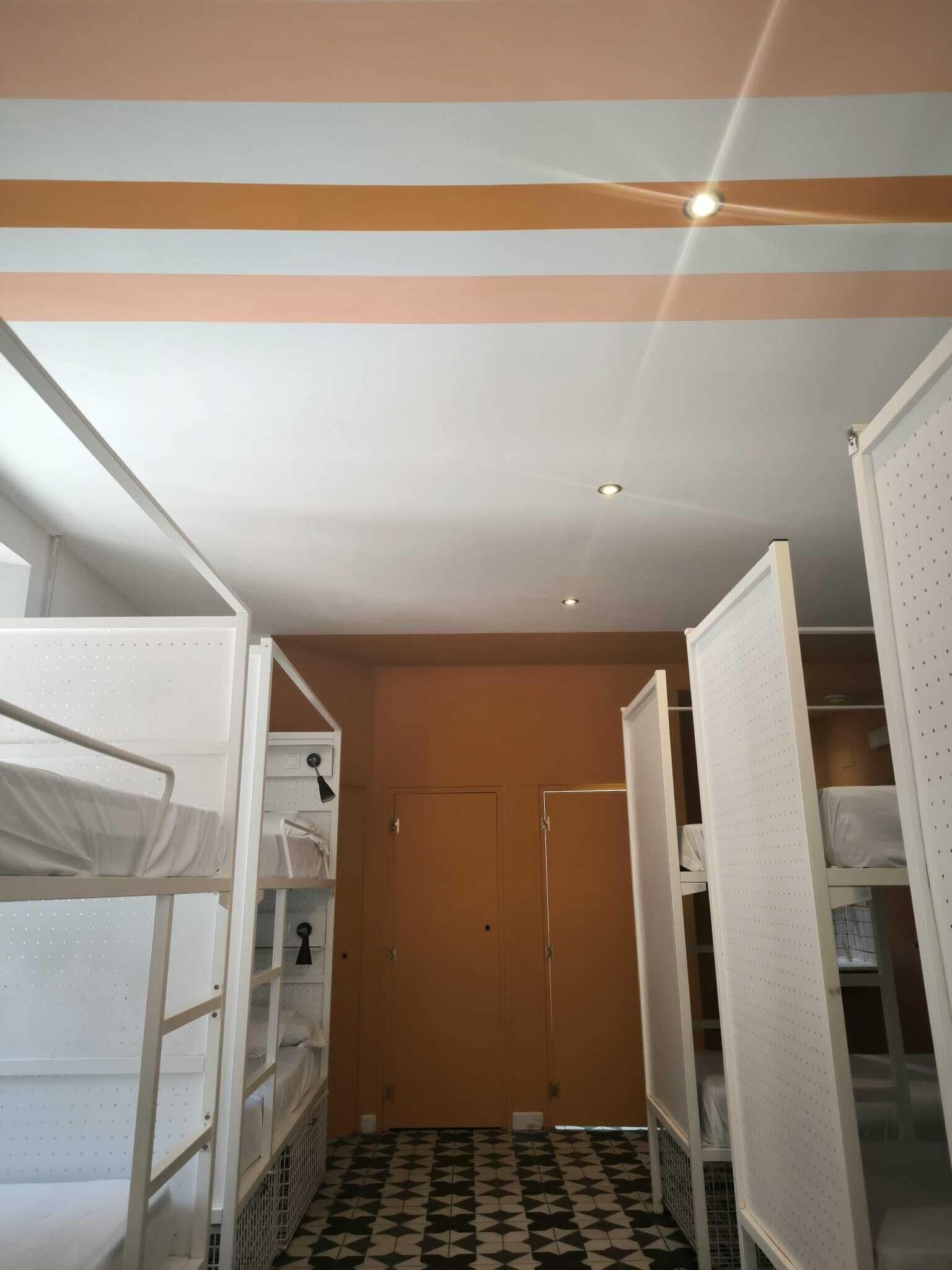 Una habitación con literas, una puerta y un piso con diseño.