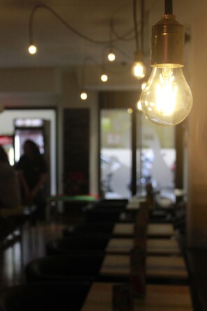A bar area with hanging light bulbs and a bar counter. - Feel Hostels Soho Malaga (Málaga)
