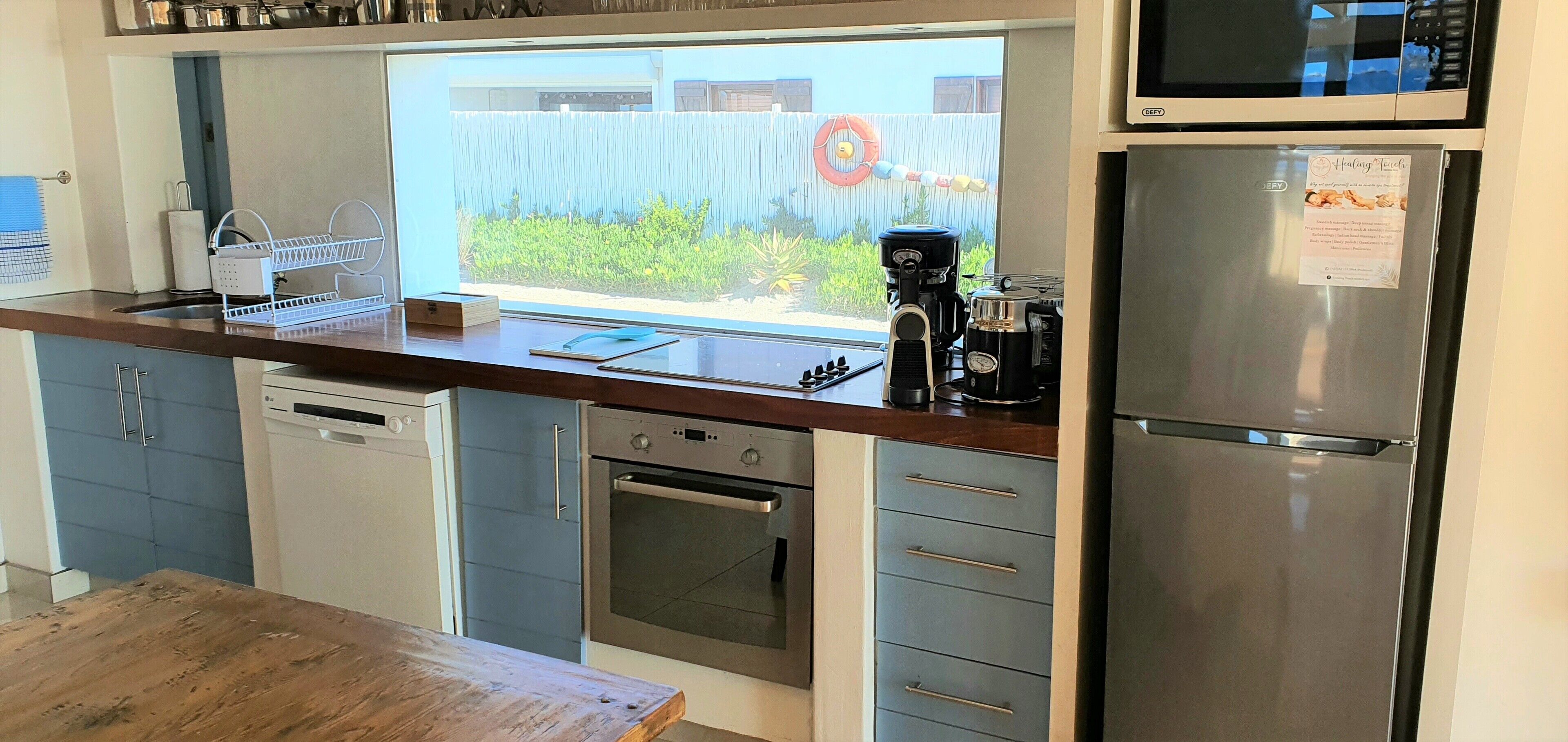 A modern kitchen with stainless steel appliances, a dishwasher, an oven, and a refrigerator.