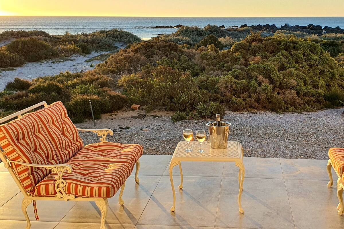An outdoor seating area with a view of the beach and ocean.
