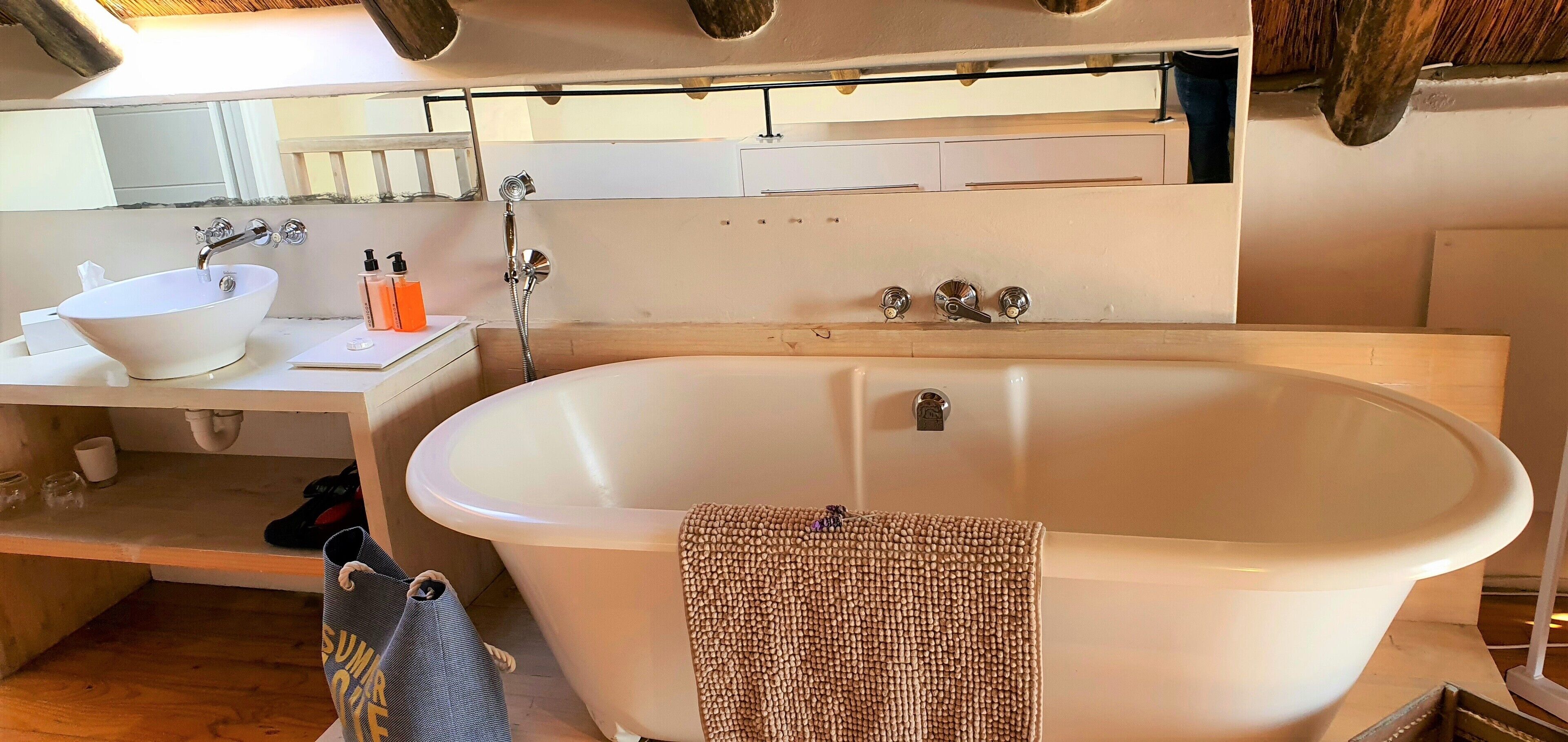 A modern bathroom with a freestanding bathtub, a sink, and a mirror above the sink.