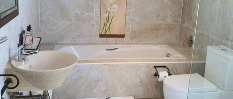 A bathroom with a freestanding sink, a bathtub, and a toilet.