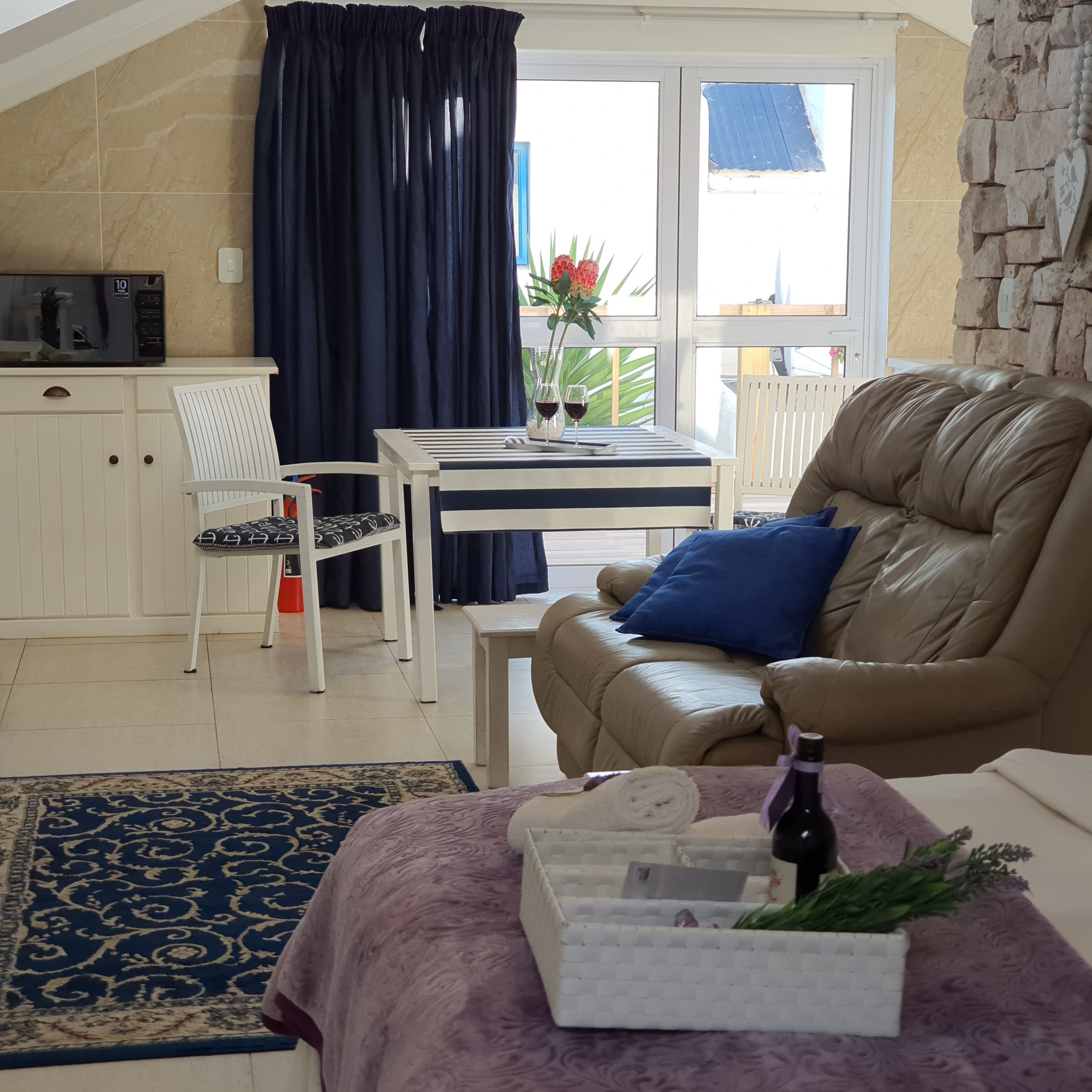 A cozy living area with a sofa, a dining table, and a kitchen area with a microwave.