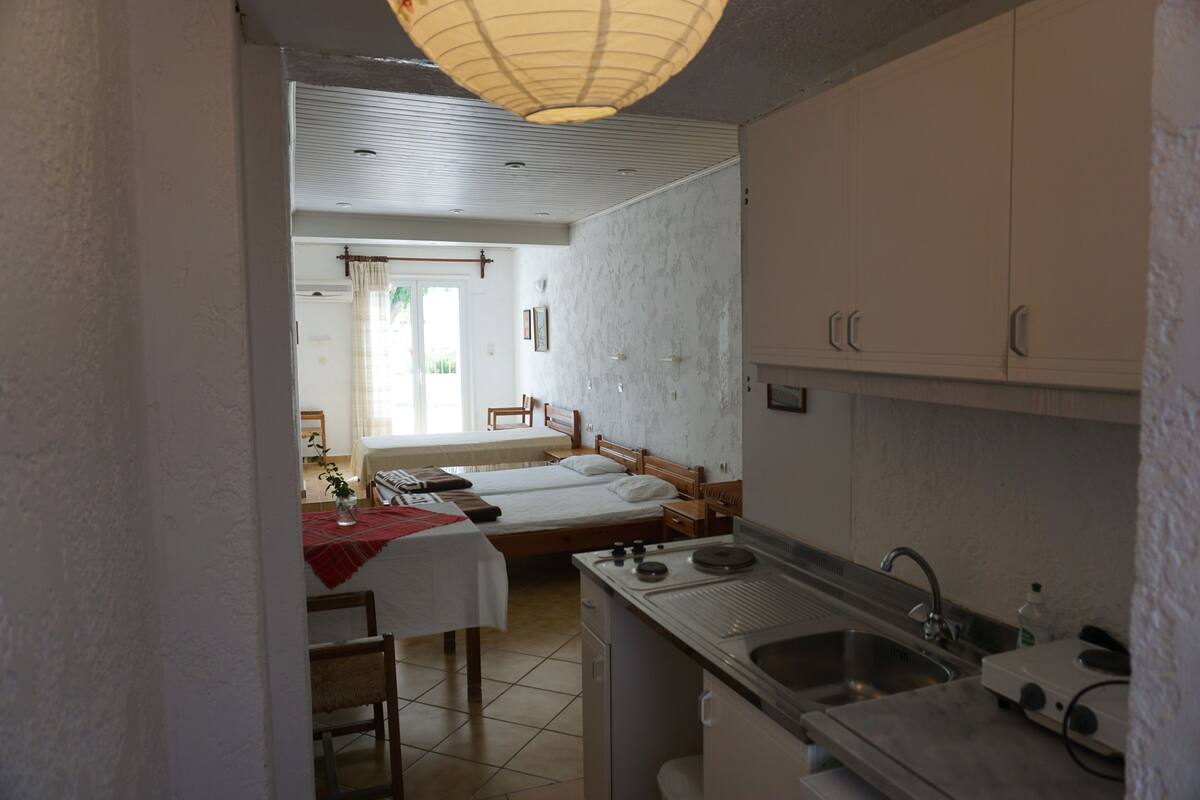 Une cuisine compacte équipée d’un évier, d’une cuisinière et d’un coin repas avec une table et des chaises.
