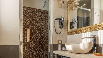 A modern bathroom with a glass-enclosed shower, a large mirror, and a white sink.