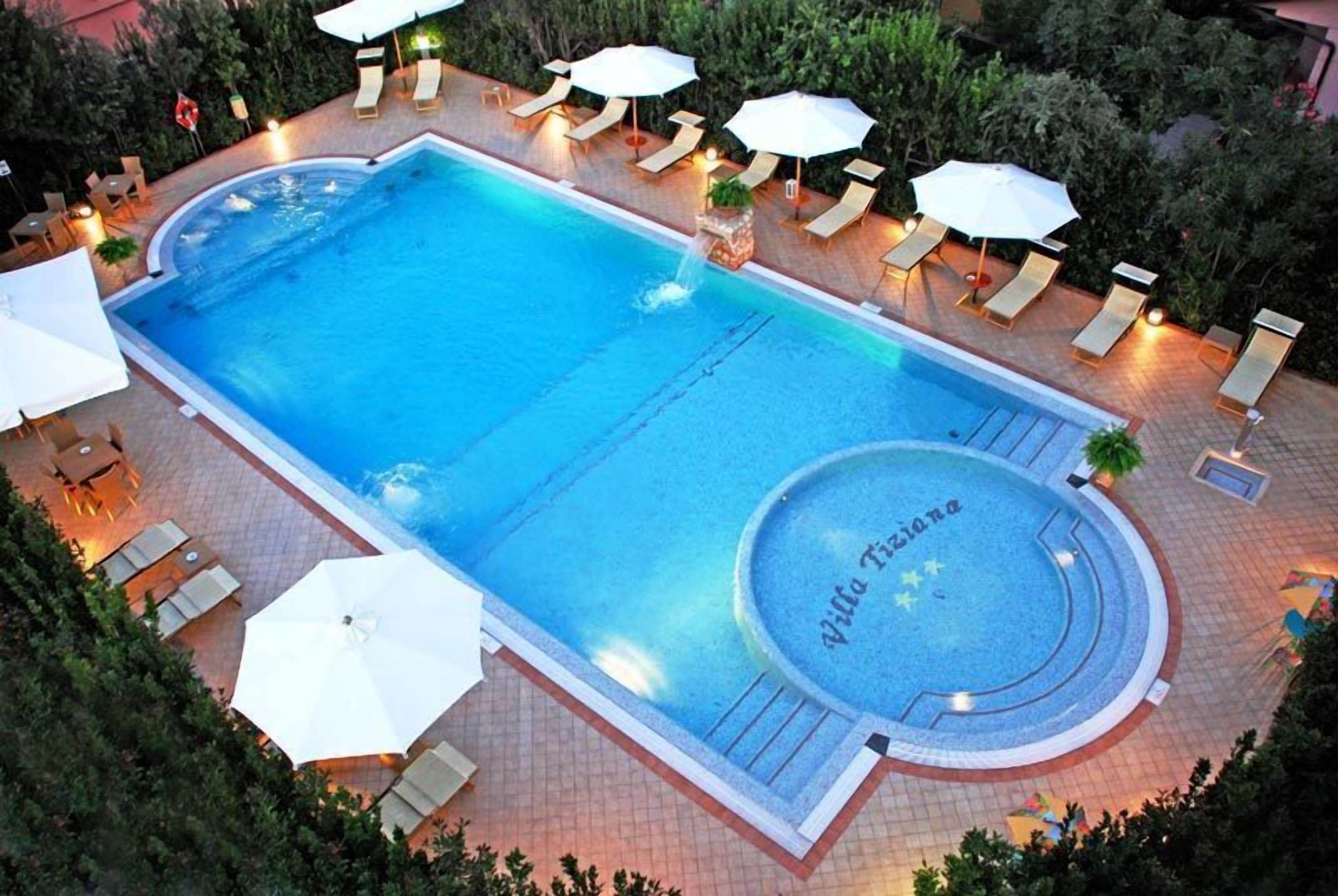 Une piscine rectangulaire avec un espace de jacuzzi circulaire, portant l’inscription « Villa Toscane ».