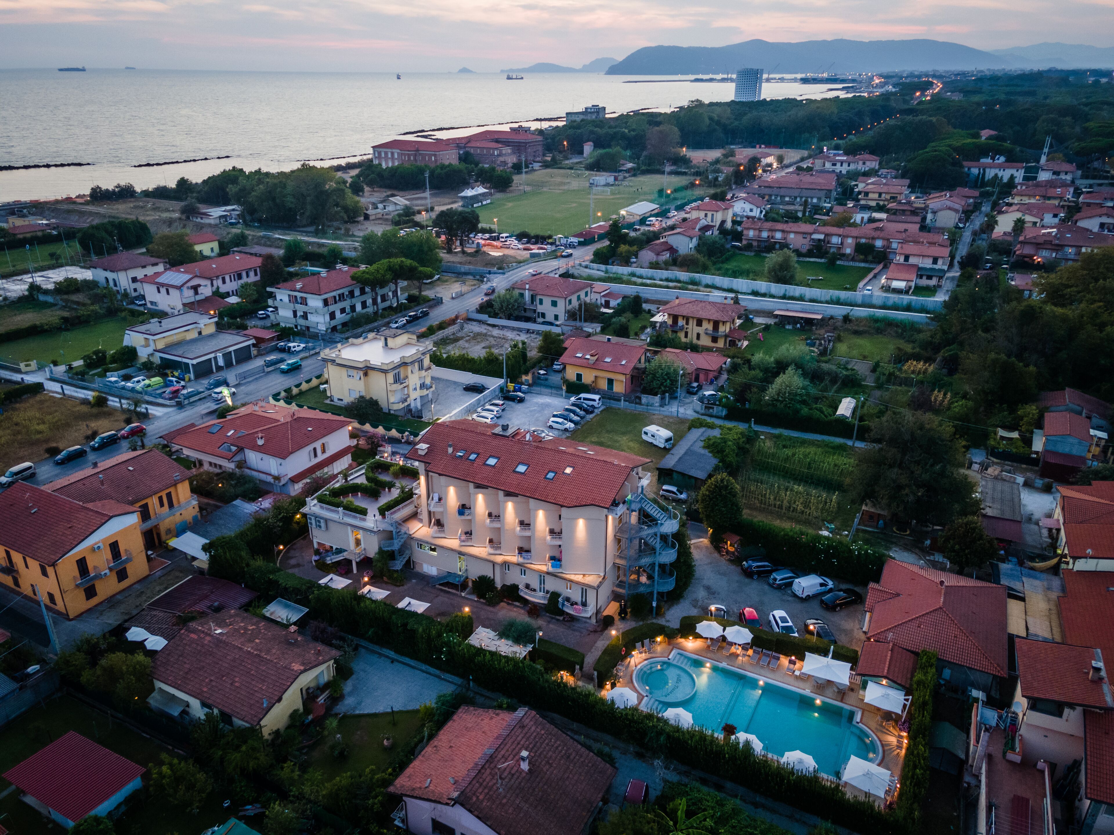 Vista aérea de una zona residencial con casas, piscina y acceso al agua.