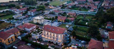An aerial view of a residential area with houses, a swimming pool, and a waterfront.