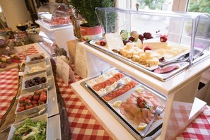 A buffet with various food options including cheeses, meats, and salads.