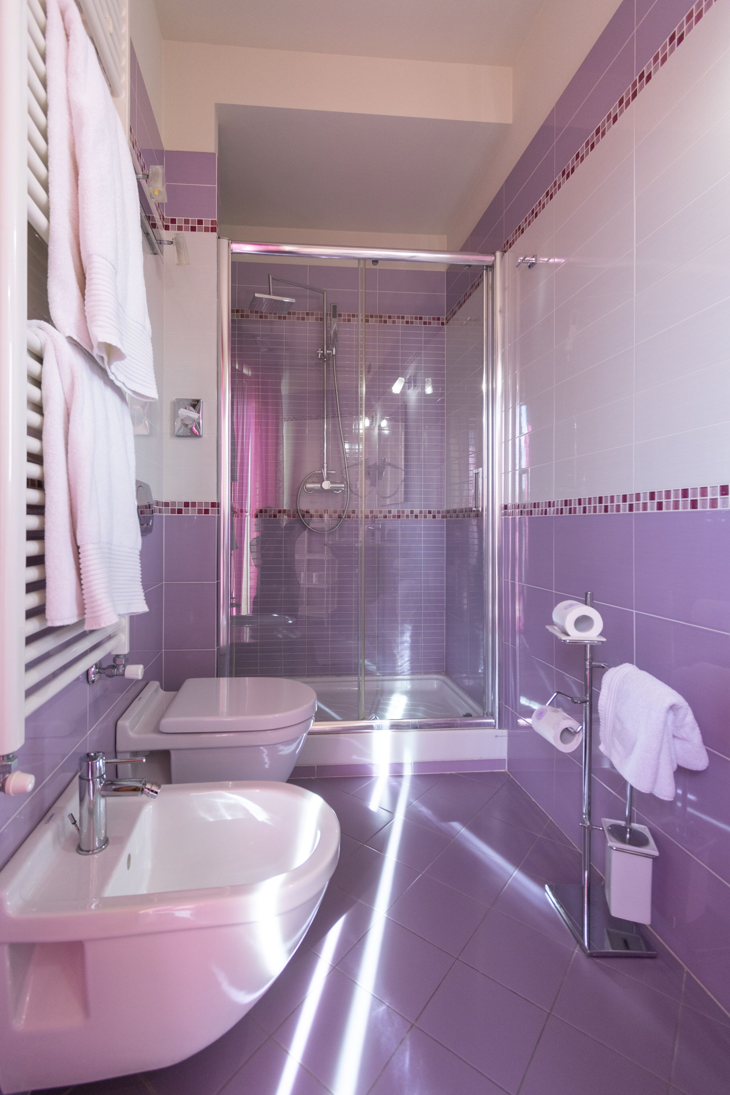 A bathroom with a shower, toilet, and sink.