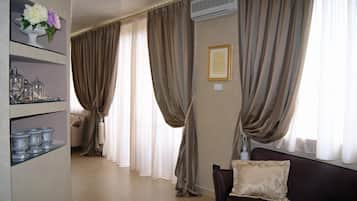 A living room with a sofa, a decorative shelf with vases, and a large window with curtains.