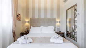 Ein Hotelzimmer mit einem großen Bett, zwei Nachttischen, einem Spiegel und einer gestreiften Wand.