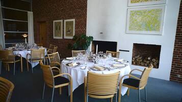 Un restaurante con paredes de ladrillo, manteles blancos y sillas de madera.
