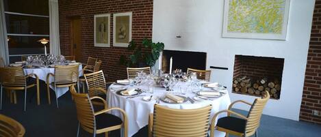 Un restaurante con paredes de ladrillo, manteles blancos y sillas de madera.