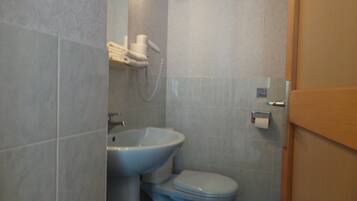 Een badkamer met een wastafel, toilet en handdoekhouder.