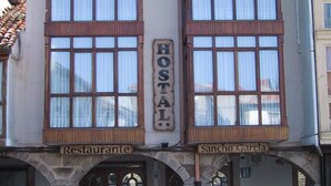 A two-story building with a sign reading "Hotel" and two smaller signs below stating "Restaurante" and "Sancho Garcia". - Hostal Sancho Garcia (Espinosa de los Monteros)