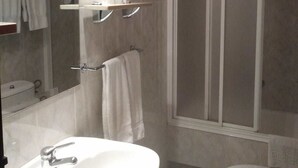 A bathroom with a sink, toilet, and shower. - Hostal Sancho Garcia (Espinosa de los Monteros)