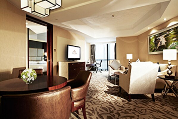 A hotel room with a dining table, chairs, a sofa, a TV, and a painting on the wall. - Kuntai Hotel Beijing (Beijing)