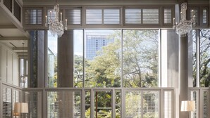 Un salón espacioso con ventanas amplias, dos sofás, una mesa de centro y una araña.
