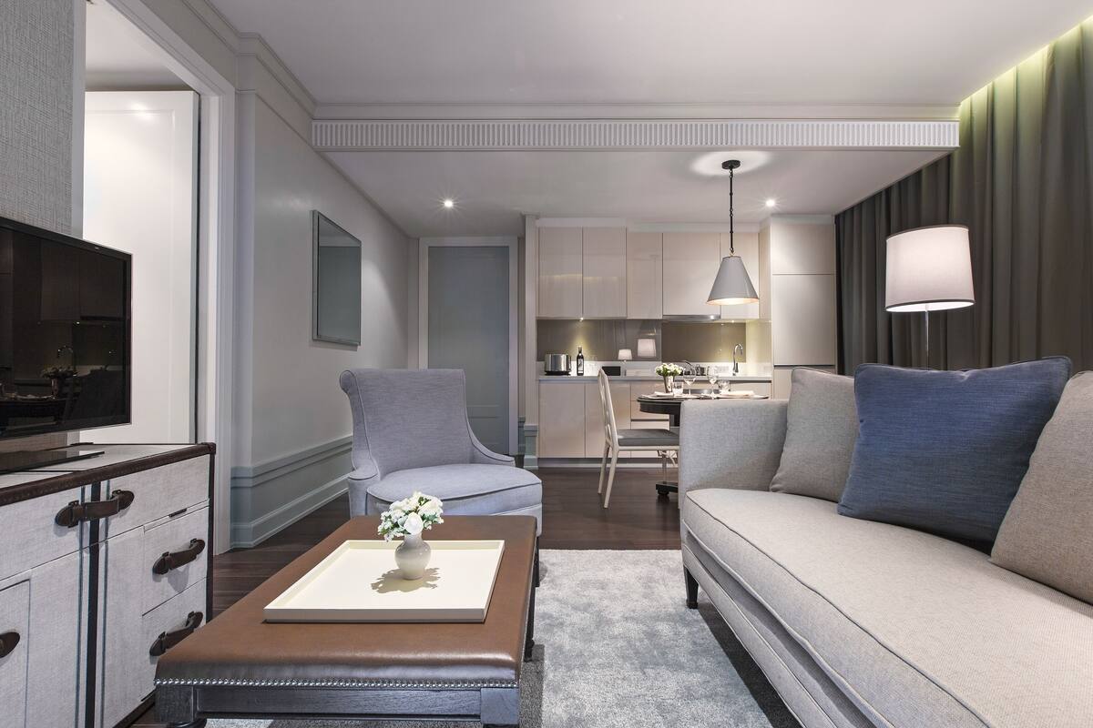 Una sala de estar moderna con un sofá, sillones, una mesa de centro y un televisor.