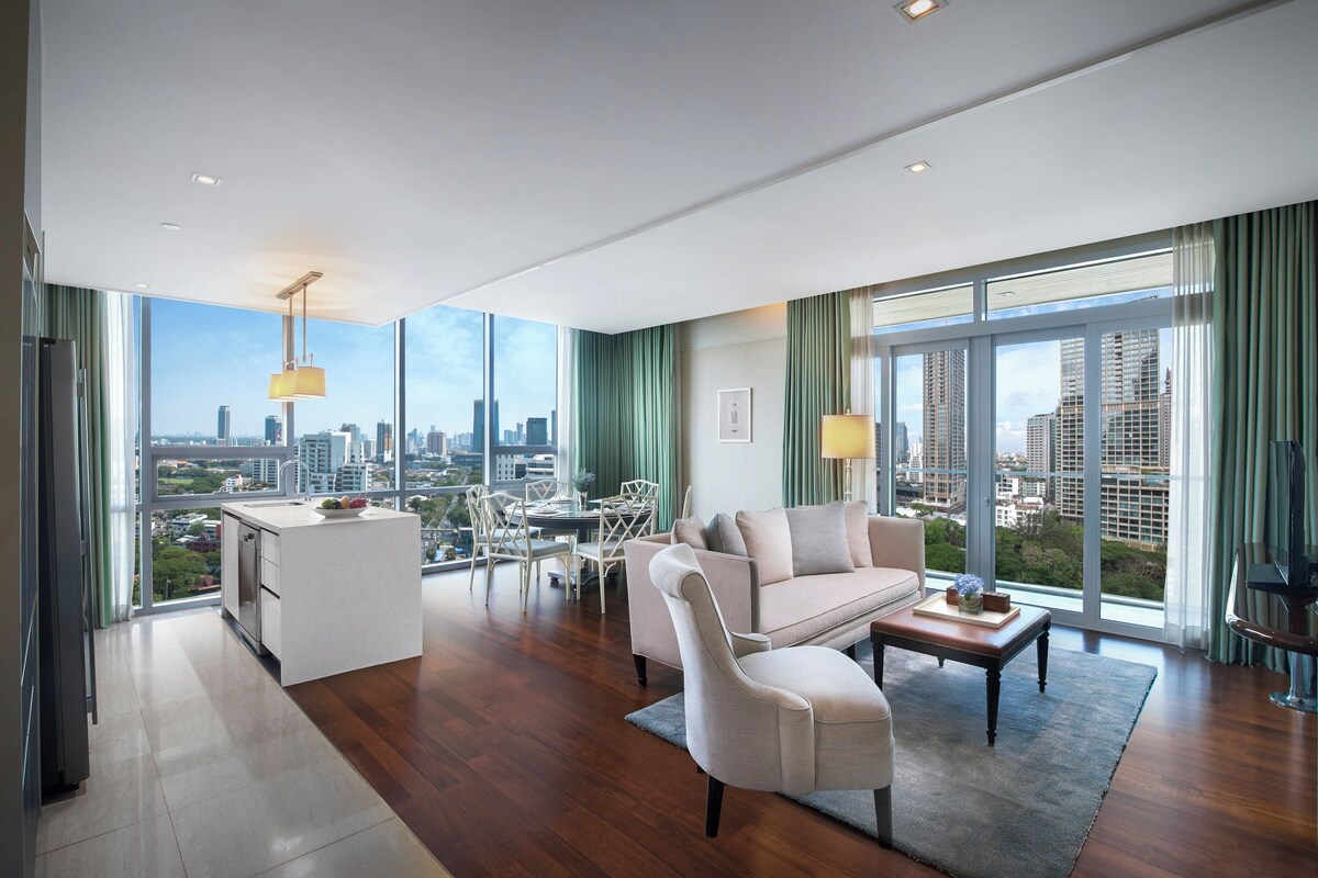 Una sala de estar moderna con vistas a la ciudad, un sofá, una mesa de centro y un comedor.