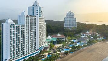 Un resort con varias edificaciones, una playa y una zona de piscina.