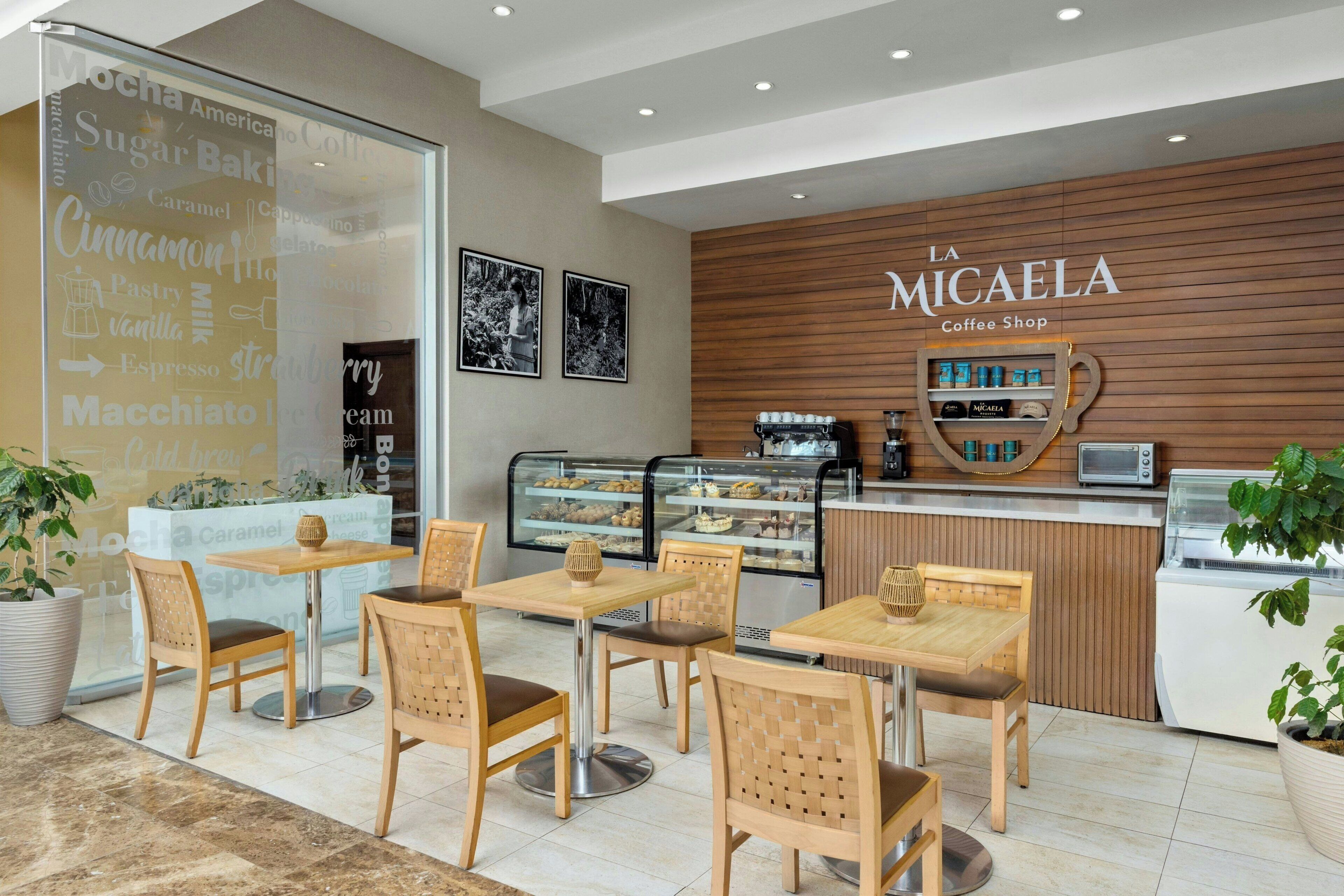 Interior de una cafetería con muebles de madera y una exhibición de productos de café.