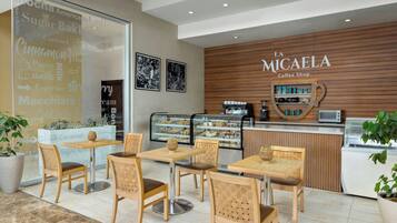 Interior de una cafetería con muebles de madera y una exhibición de productos de café.
