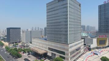 A modern high-rise building with a grid-like facade, surrounded by other contemporary structures.