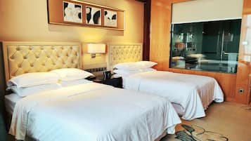 Habitación de hotel con dos camas, un ventanal grande y una obra de arte colgada en la pared.