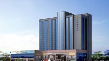 A modern high-rise building with a prominent entrance and a large glass facade.
