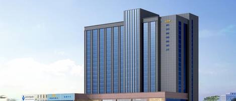A modern high-rise building with a prominent entrance and a large glass facade.