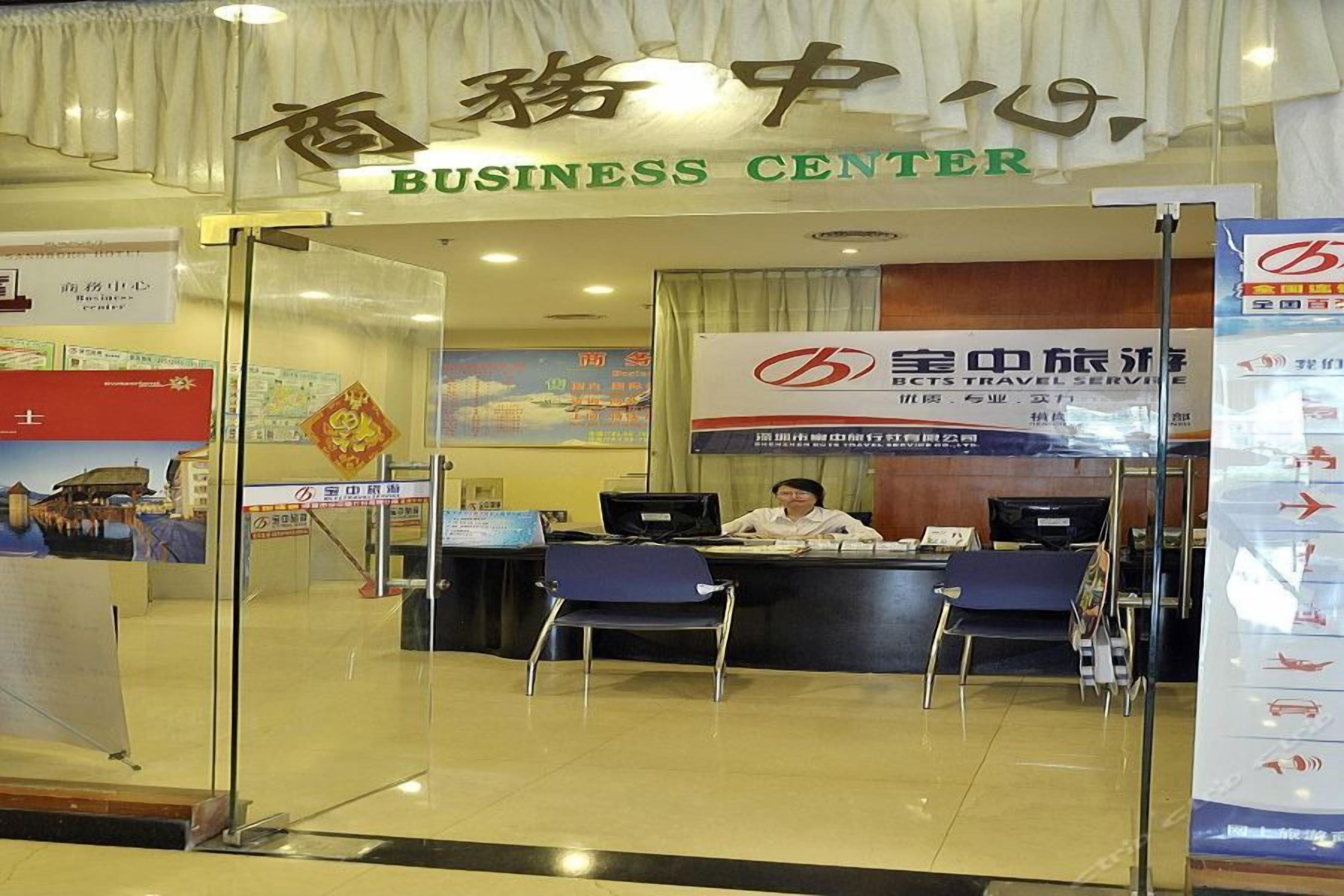A business center with a reception desk, chairs, and informational posters.