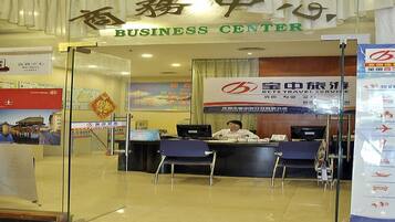 A business center with a reception desk, chairs, and informational posters.
