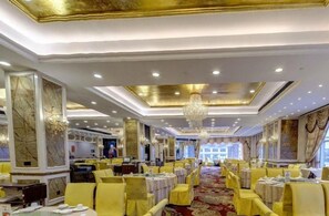 A banquet hall with round tables, chandeliers, and a red carpet. - Sandborg Hotel (Shenzhen)