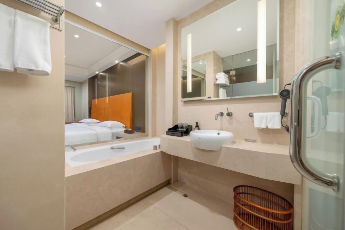 A modern bathroom with a bathtub, a sink, and a shower area.