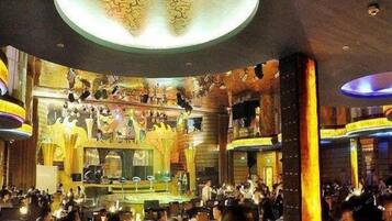 A restaurant with a central stage, multiple dining tables, and a decorative ceiling.