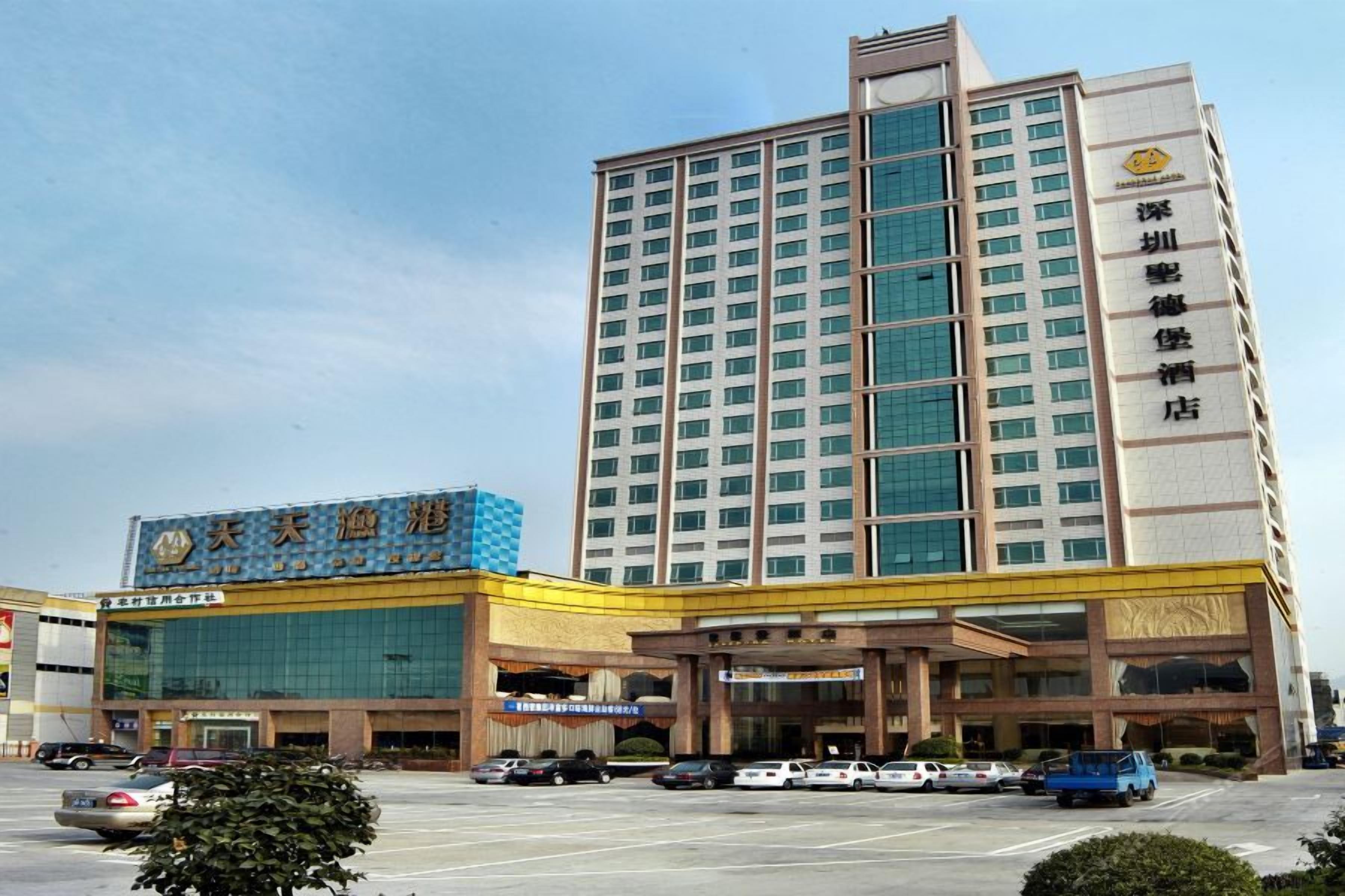 A multi-story hotel with a prominent entrance and a parking lot.