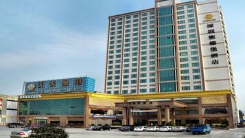 A multi-story hotel with a prominent entrance and a parking lot.