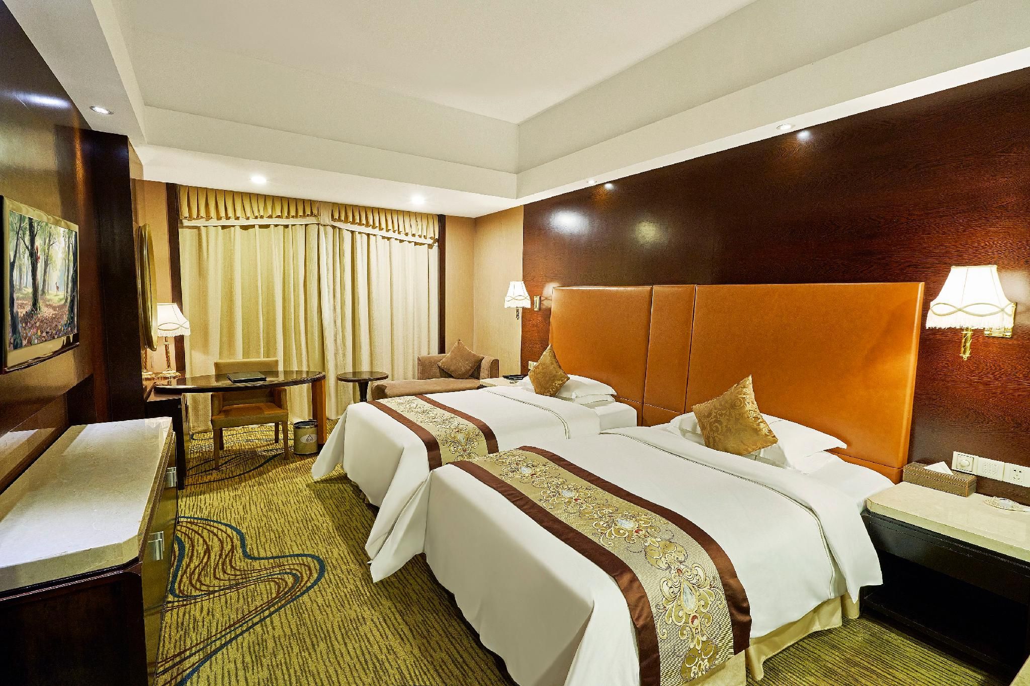 A hotel room with two beds, a desk, a chair, and a painting on the wall.